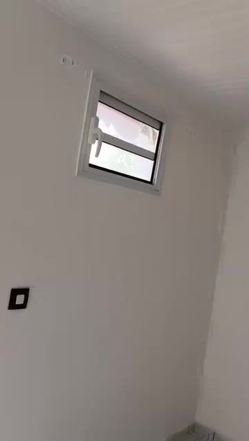 Pièce aux murs blancs repeints avec fenêtre et plafond en lambris