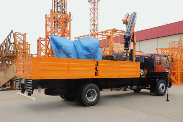 Camion équipé d’une grue auxiliaire déployée sur un chantier